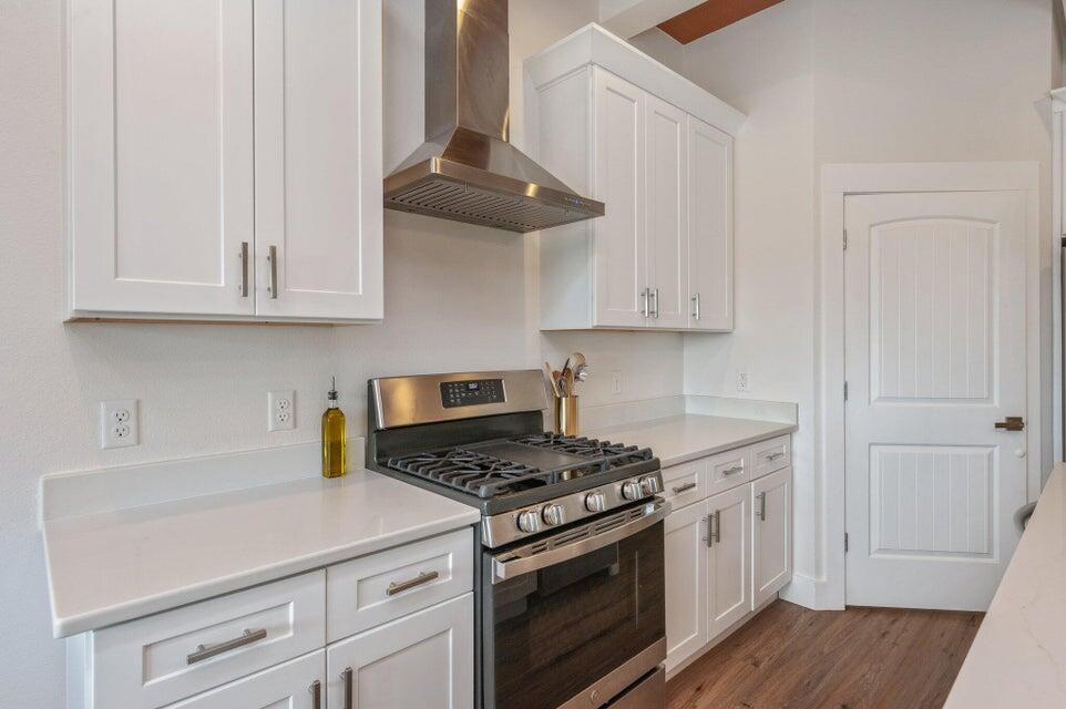 508 Harborview Circle Niceville, FL 32578 - Photo 17 of 60 a kitchen with granite countertop white cabinets and a stove with wooden floor