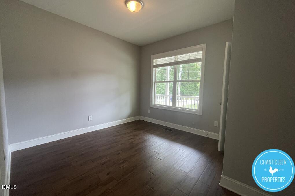 912 Chaney Road, Unit 100 Raleigh, NC 27606 - Photo 12 of 18 an empty room with wooden floor and windows