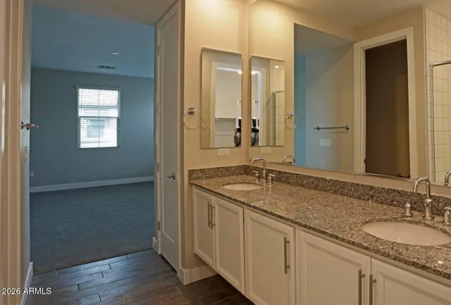 a bathroom with a granite countertop sink and a mirror