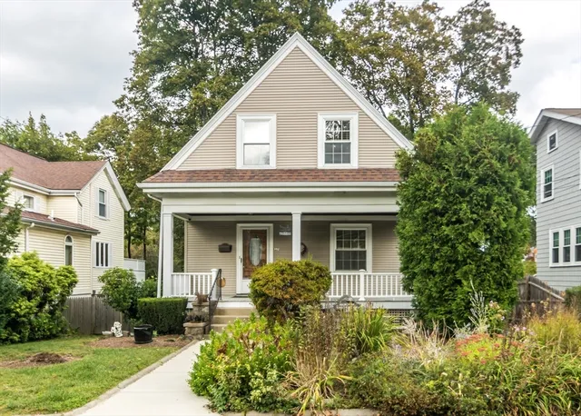a view of a house with brick walls plants and large trees