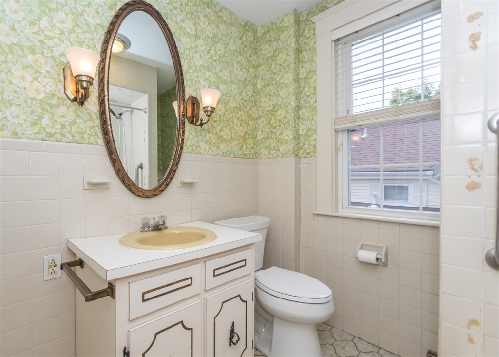 37 Summit Street Waltham, MA 02451 - Photo 24 of 29 a bathroom with a sink a mirror a toilet and a window