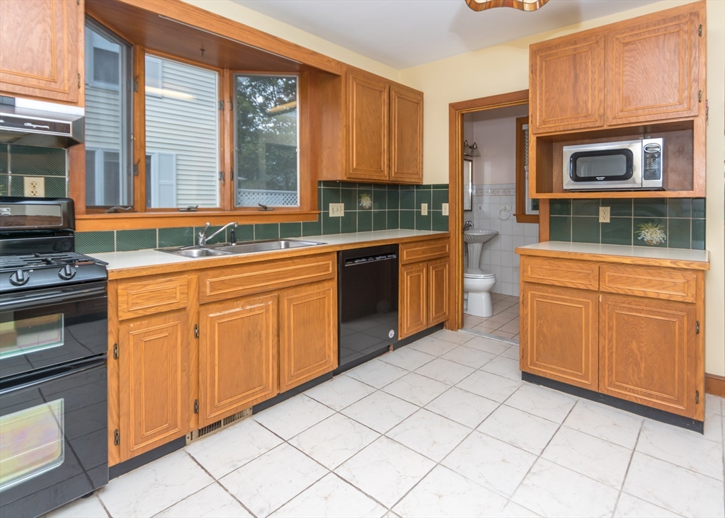 37 Summit Street Waltham, MA 02451 - Photo 8 of 29 a kitchen with stainless steel appliances granite countertop a stove a sink and a microwave