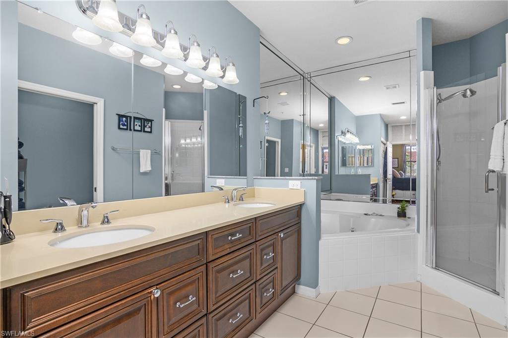 680 Lalique Circle, Unit 1205 Naples, FL 34119 - Photo 13 of 32 a spacious bathroom with a granite countertop sink a toilet a mirror and shower
