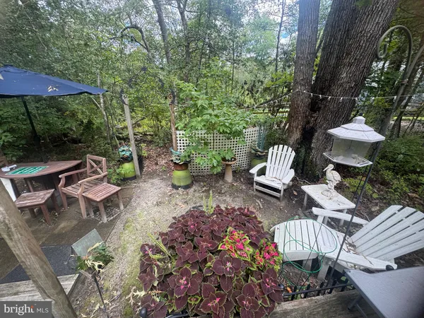 a view of a patio with furniture and a garden