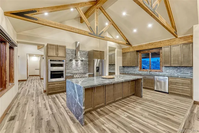 a large kitchen with stainless steel appliances granite countertop a stove and cabinets