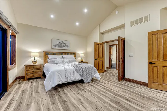 a bedroom with a bed and wooden floor