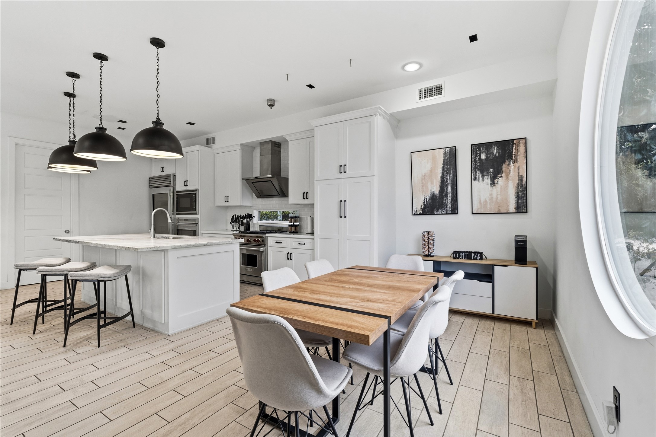 2025 Colquitt Street, Unit A Houston, TX 77098 - Photo 17 of 40 a kitchen that has a table chairs in it and wooden floors