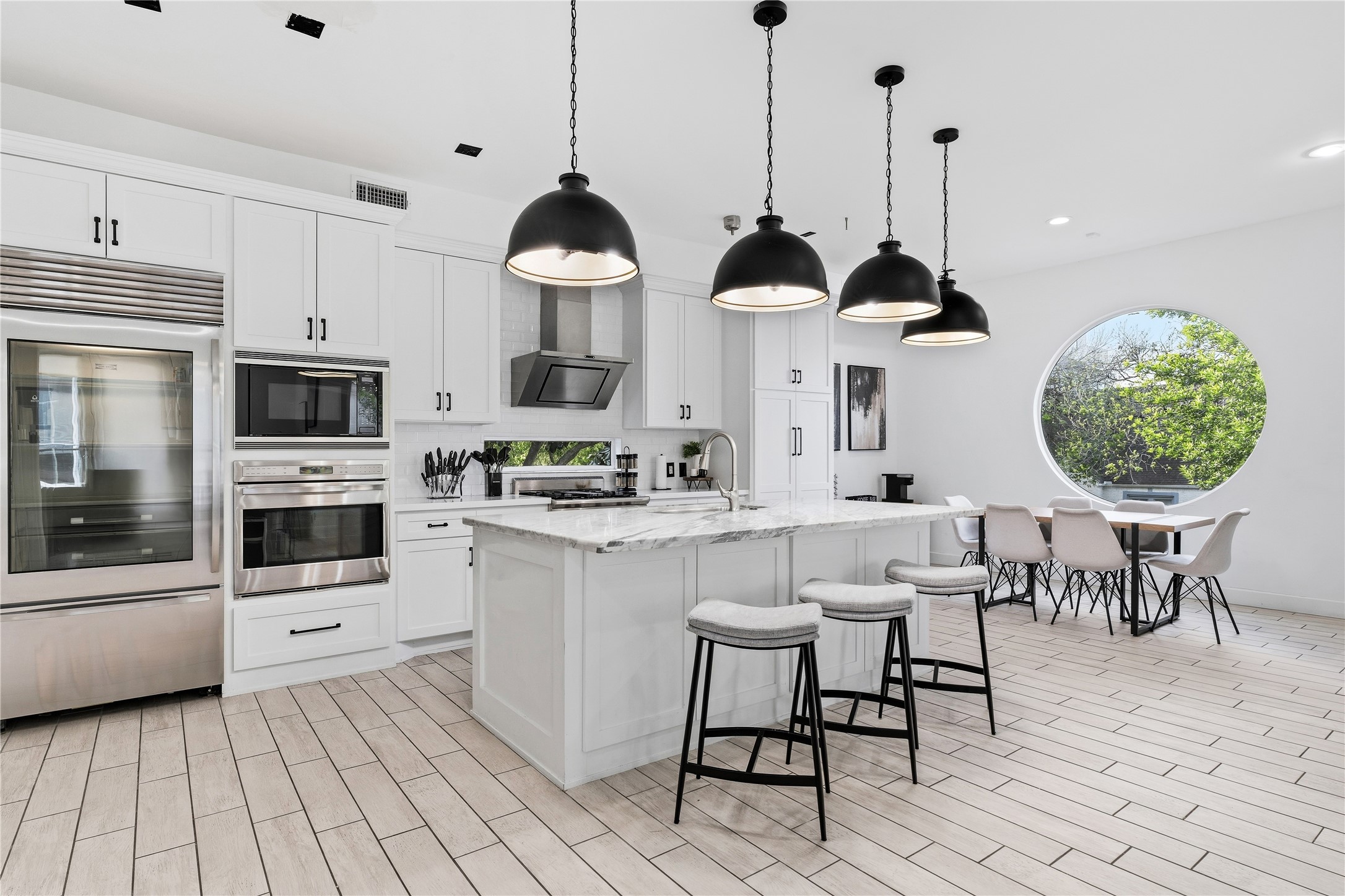 2025 Colquitt Street, Unit A Houston, TX 77098 - Photo 9 of 40 a view of kitchen with stainless steel appliances kitchen island granite countertop a stove a sink a dining table and chairs