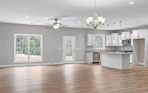 a view of a kitchen with granite countertop a large counter space stainless steel appliances and cabinets