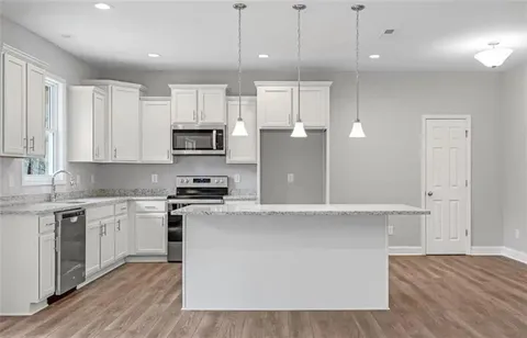 a kitchen with stainless steel appliances granite countertop a stove a sink and a refrigerator