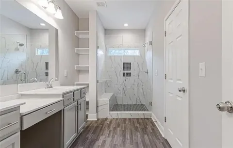 a bathroom with a sink a shower and a mirror
