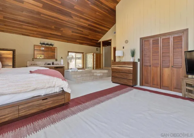 a spacious bedroom with a bed and a view of bedroom