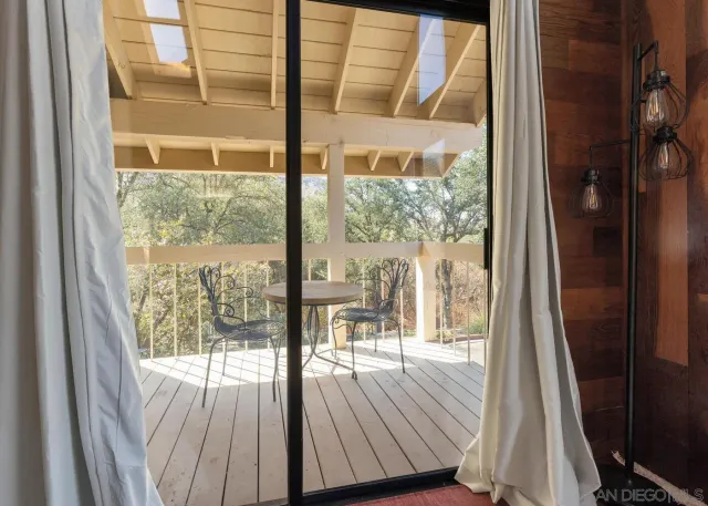 a view of a room with wooden floor and floor to ceiling windows