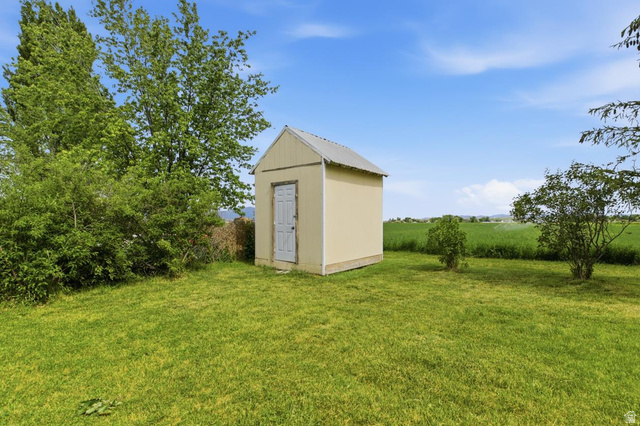 435 East 4th North Preston, ID 83263 - Photo 24 of 26 Detached storage shed featuring a light-colored exterior and a white door, set upon a green lawn