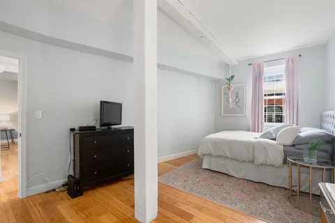 a living room with a bed and a television