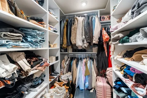 a view of walk in closet with clothes and shoes