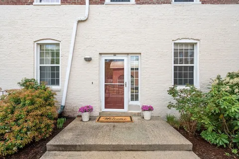 a view of a brick house with potted plants