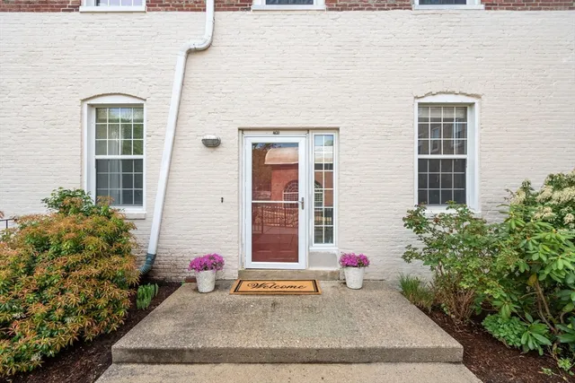 a view of a brick house with potted plants