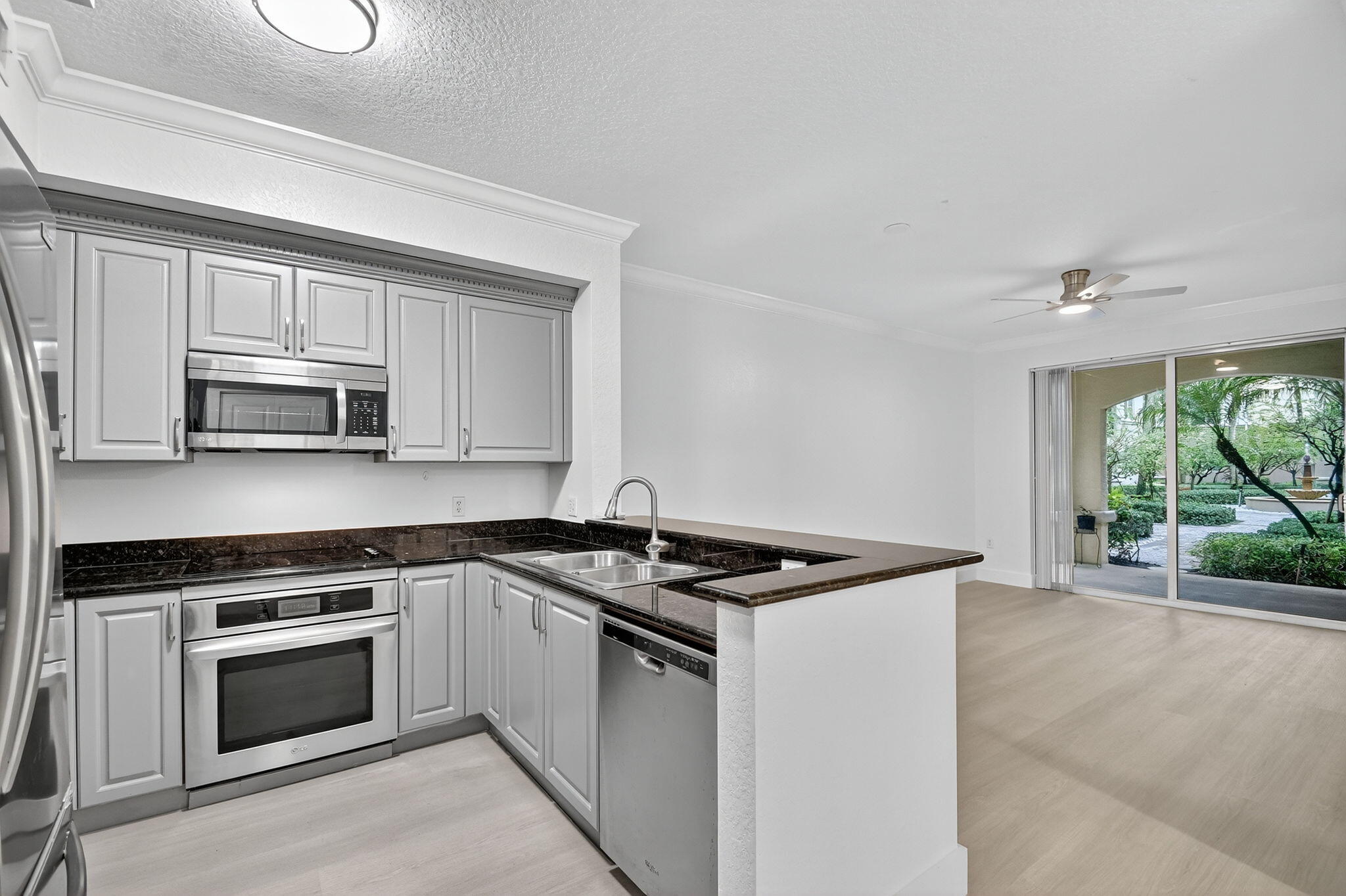 1 Renaissance Way, Unit 116 Boynton Beach, FL 33426 - Photo 5 of 34 a kitchen with granite countertop white cabinets and white appliances