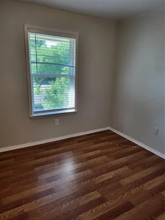 a view of a room with wooden floor and window