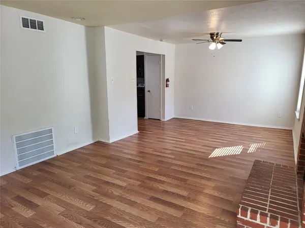 a view of an empty room with wooden floor