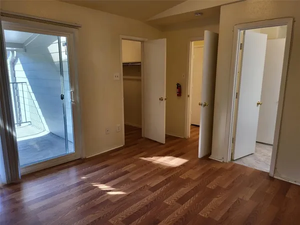 a view of a room with wooden floor and door