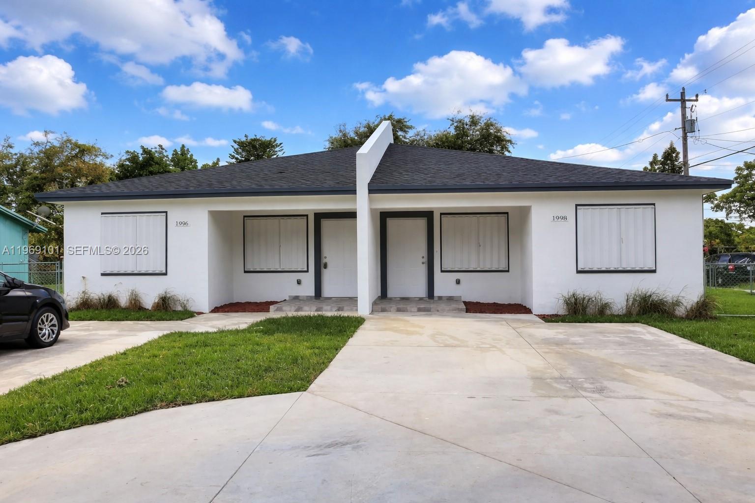 1998 Northwest 47th Street Miami, FL 33142 - Photo 1 of 17 a view of a house with a yard and garage