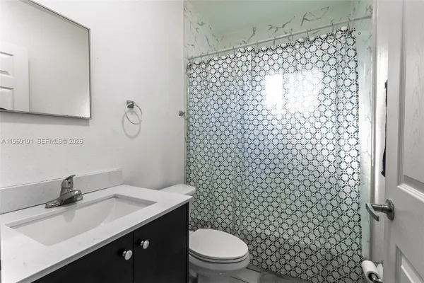 a bathroom with a sink toilet and shower