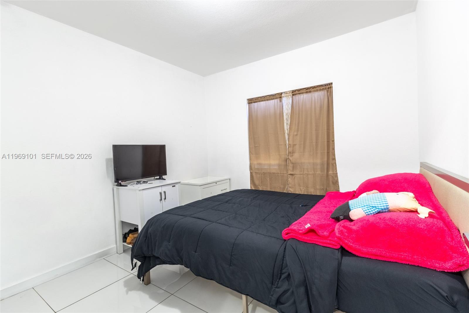 1998 Northwest 47th Street Miami, FL 33142 - Photo 15 of 17 a bedroom with a bed and a flat screen tv