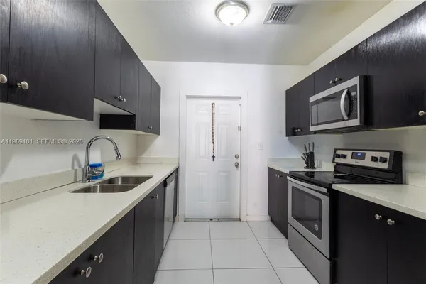 a kitchen with stainless steel appliances granite countertop a sink and a stove