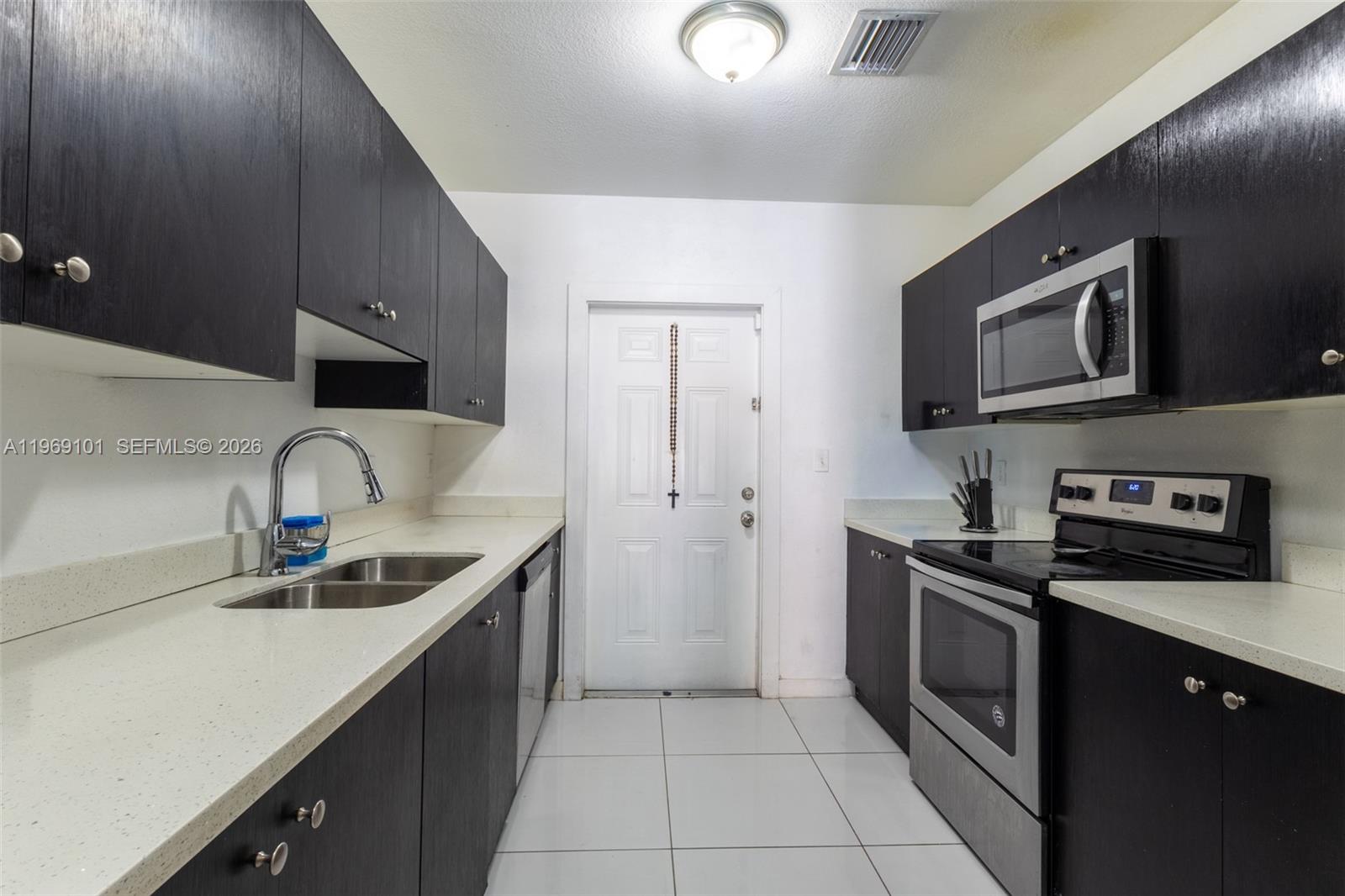 1998 Northwest 47th Street Miami, FL 33142 - Photo 3 of 17 a kitchen with stainless steel appliances granite countertop a sink and a stove