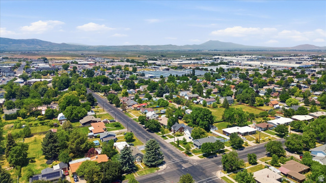 395 North 400 West Logan, UT 84321 - Photo 40 of 48 Expansive aerial perspective showcasing a residential area with mature tree-lined streets, single-story homes, and distant mountain ranges