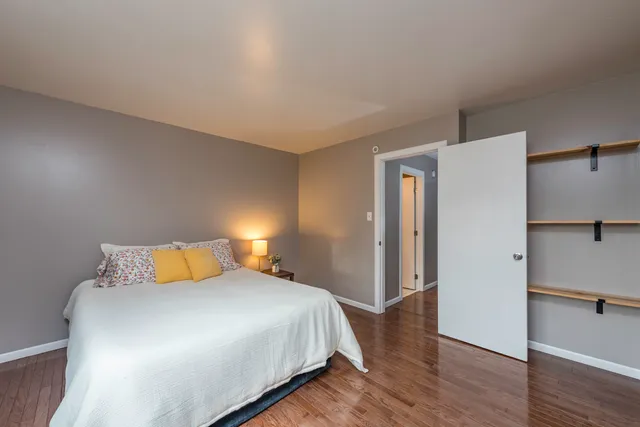 a bedroom with a bed and wooden floor