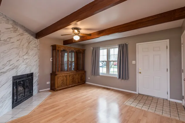 a view of an empty room with a fireplace and a window
