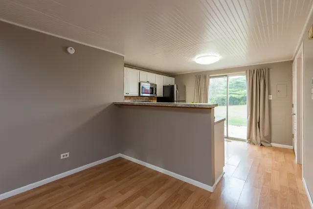 a view of a kitchen with wooden floor and a window