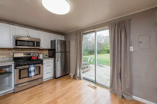 a kitchen with granite countertop a refrigerator and a stove top oven