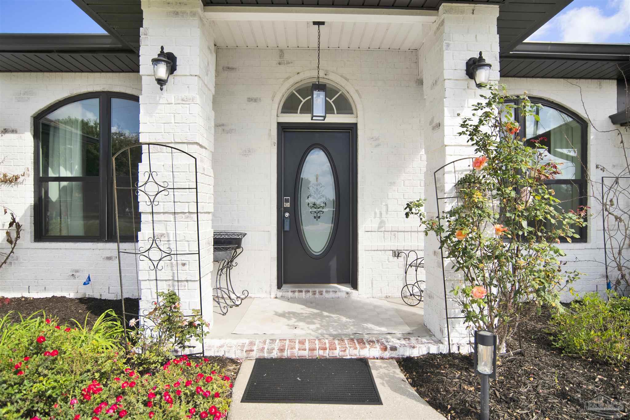 2810 Wallace Lake Road Pace, FL 32571 - Photo 4 of 65 a front view of a house with a garden