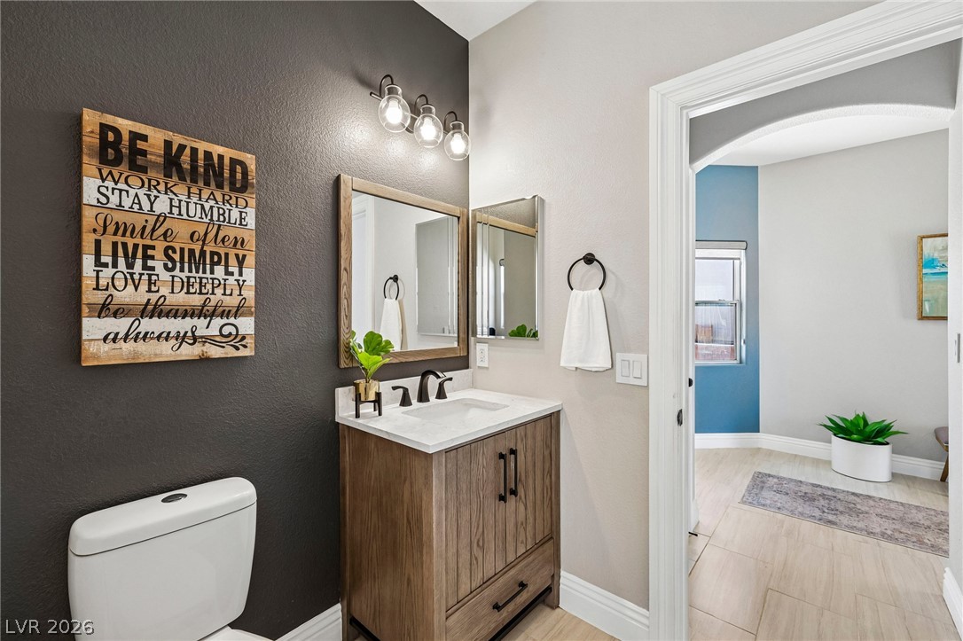 1176 Butternut Ranch Court Henderson, NV 89052 - Photo 18 of 60 A well-lit powder room showcases a rustic vanity with a modern sink and tasteful lighting.