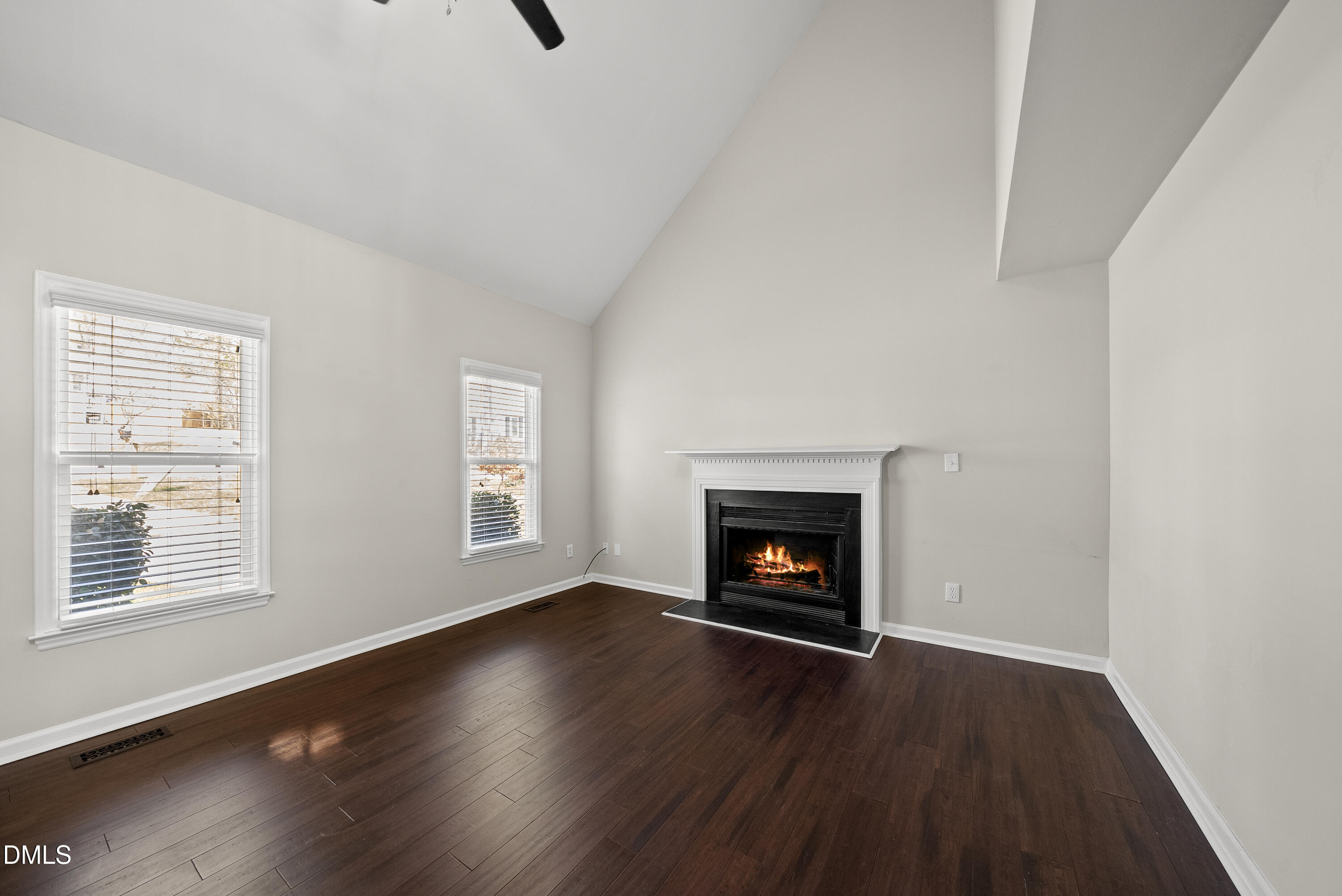8324 Bellingham Circle Raleigh, NC 27615 - Photo 7 of 34 an empty room with wooden floor fire place and windows