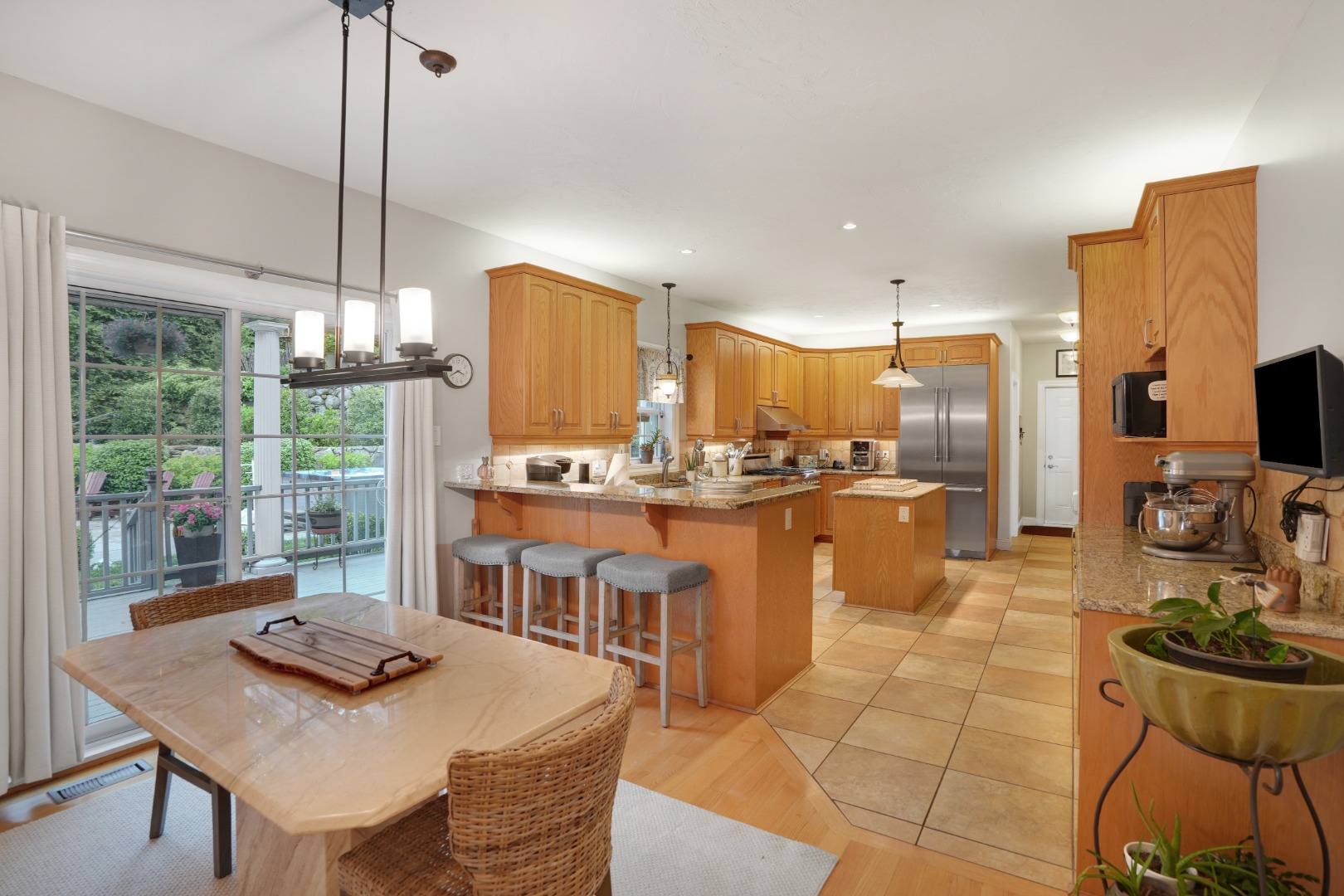 8 Fresh Pond Road Oak Bluffs, MA 02557 - Photo 4 of 36 a kitchen with stainless steel appliances granite countertop a stove a refrigerator a kitchen island a table and chairs in it