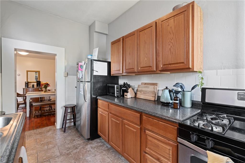 4123 Foster Street Pittsburgh, PA 15201 - Photo 11 of 31 a kitchen with granite countertop wooden cabinets and stainless steel appliances