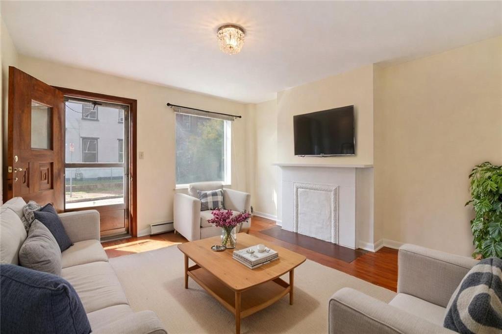 4123 Foster Street Pittsburgh, PA 15201 - Photo 4 of 31 a living room with furniture a flat screen tv and a large window