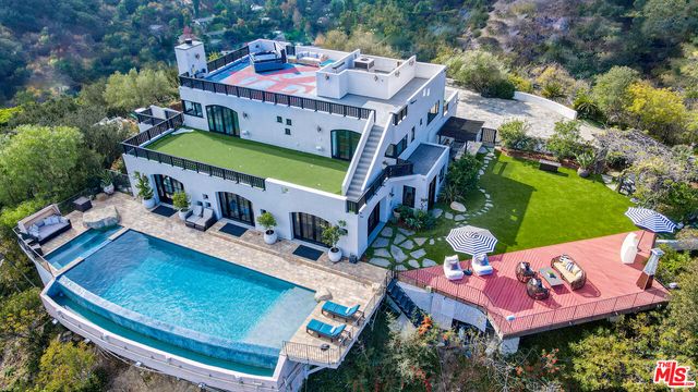an aerial view of a house with a swimming pool patio and outdoor seating
