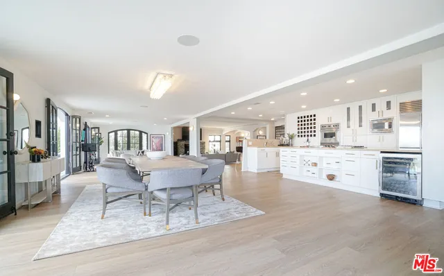 a kitchen with stainless steel appliances kitchen island wooden floors granite counter tops and a view of living room