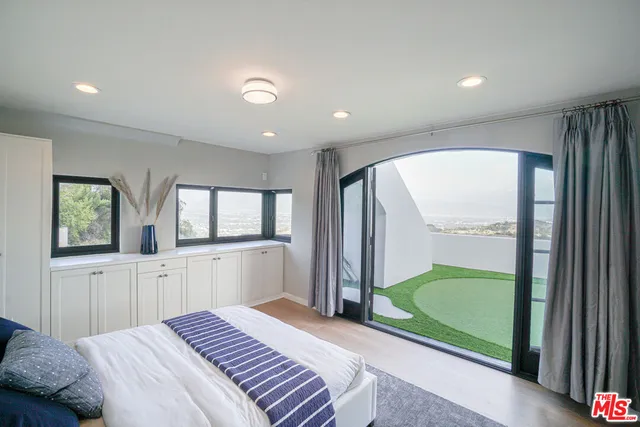 a spacious bedroom with a large bed and a large window