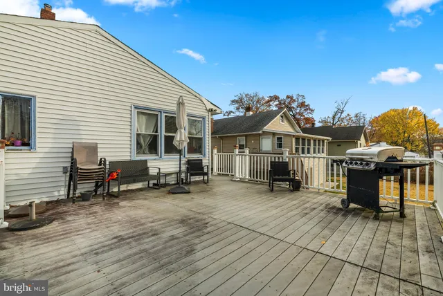 a view of a house with wooden deck and furniture