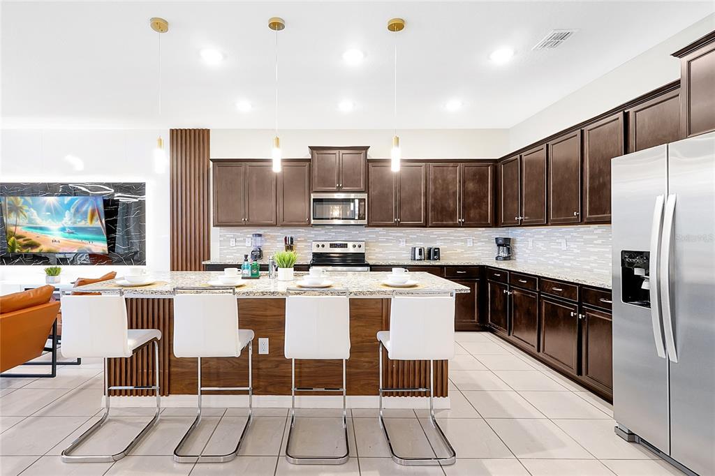 4494 Kaipo Road Davenport, FL 33897 - Photo 13 of 100 a kitchen with a sink a counter top space appliances and cabinets