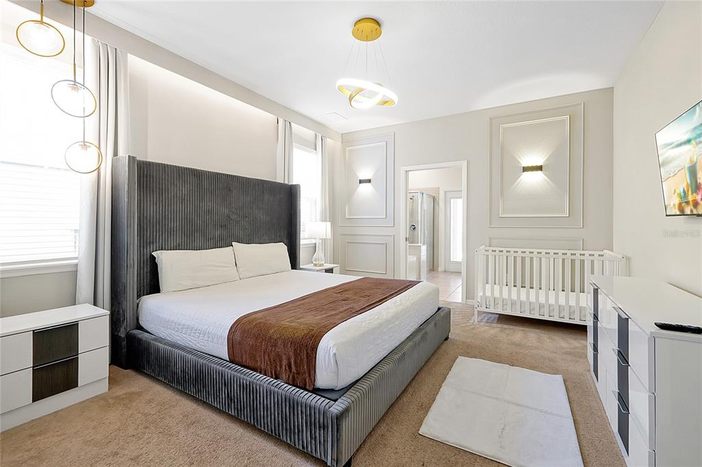 4494 Kaipo Road Davenport, FL 33897 - Photo 33 of 100 a bedroom with a bed a mirror and a window