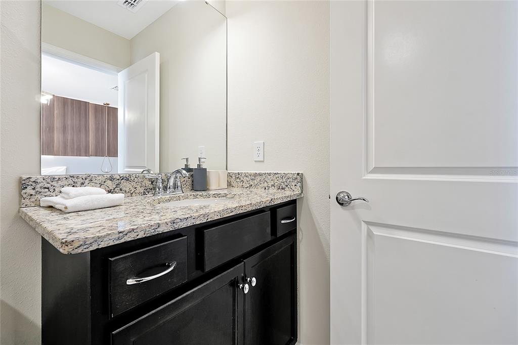 4494 Kaipo Road Davenport, FL 33897 - Photo 62 of 100 a bathroom with a granite countertop sink and a mirror