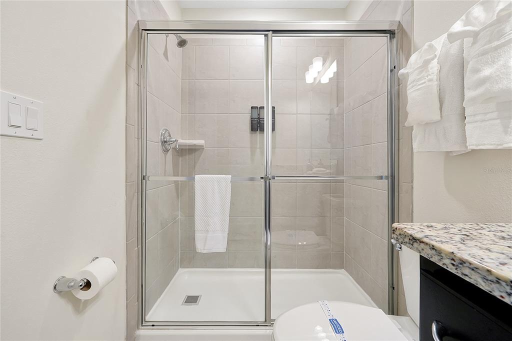4494 Kaipo Road Davenport, FL 33897 - Photo 68 of 100 a bathroom with a granite countertop shower and a sink